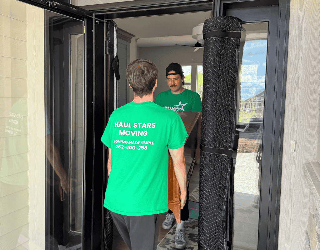 Two Haul Stars Moving team members loading furniture into a portable container outside a Milwaukee residence