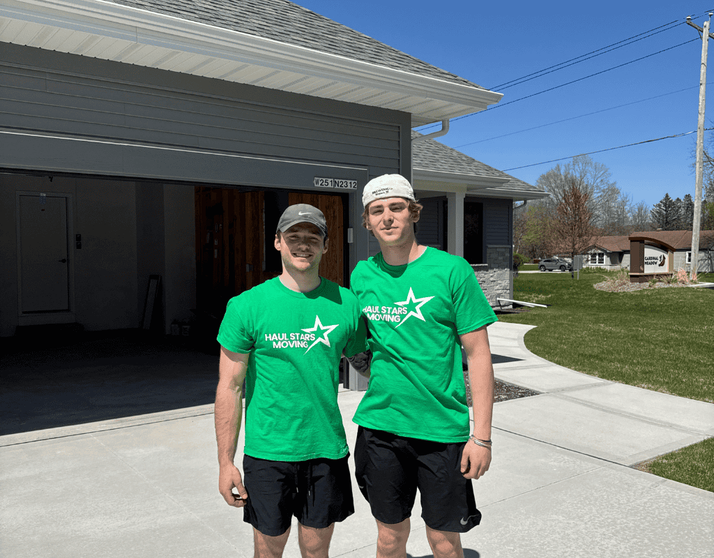 Two smiling Haul Stars Moving crew members standing outside a Milwaukee apartment building after a move
