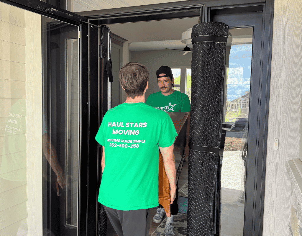 Two Haul Stars Moving crew carrying furniture through a doorway while unpacking in a Milwaukee residence